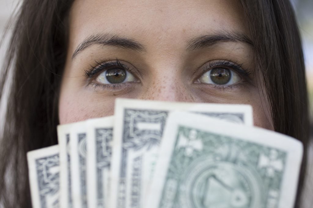 woman holding money over her face