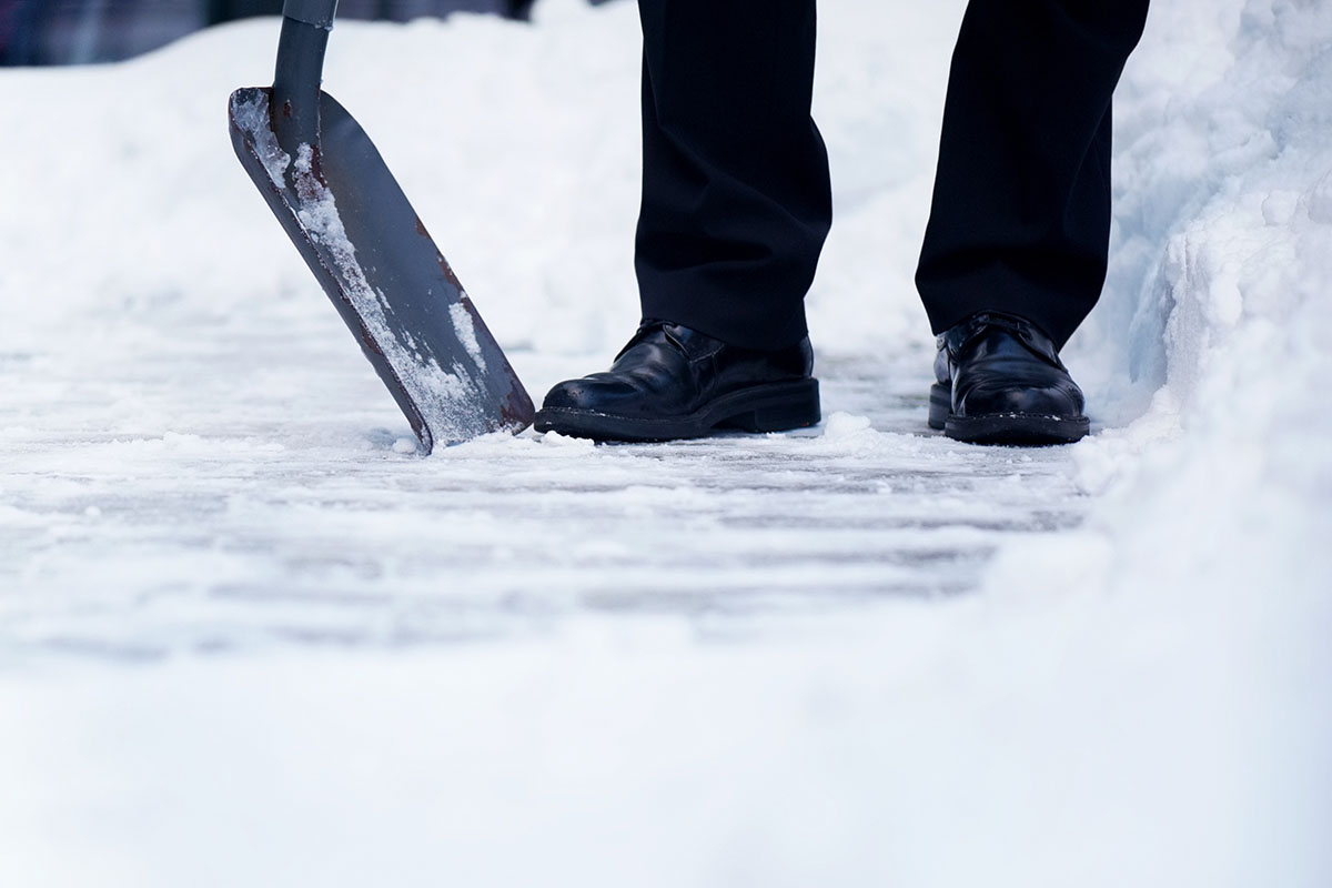 Welldressed man with snow shovel