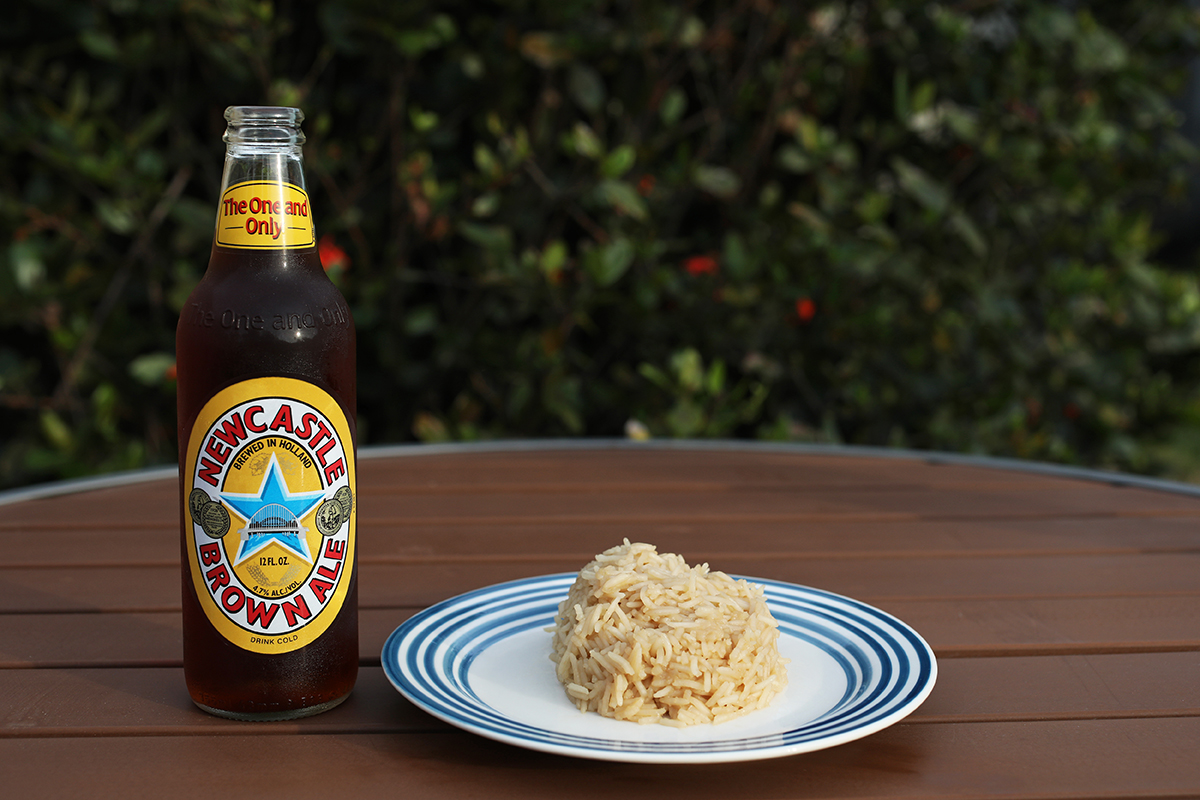 Beer rice sits on a table with a brown ale next to it.