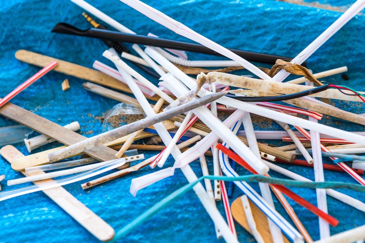 discarded plastic straws on a tarp.