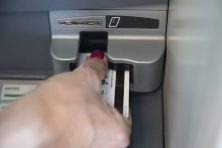 Kaye Kingkade withdrawals money out of the ATM at Mount McKinley Bank in Fairbanks, Alaska.