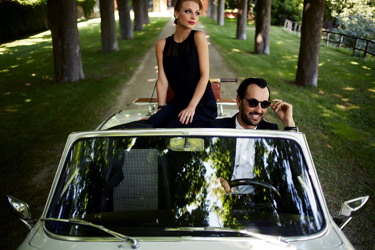 Young rich couple travel on the new white convertible