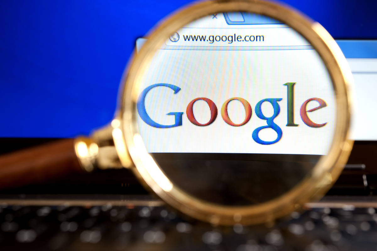 Close up to Google website through a magnifying glass on the laptop