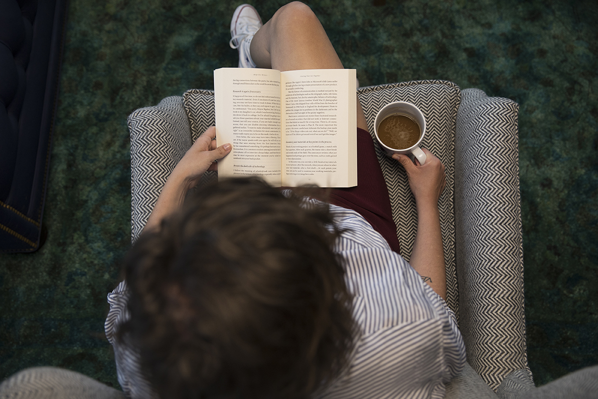 woman reading book in chair