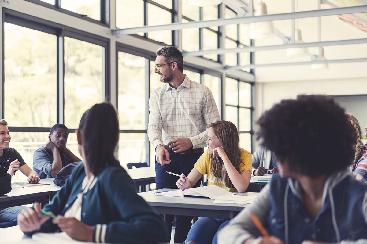 Smiling mature professor teaching in classroom