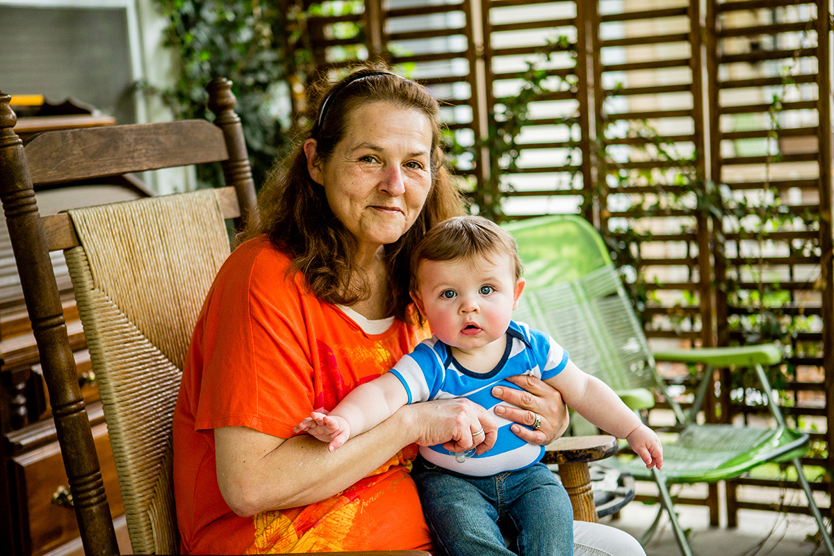 Patricia Holland sits on the front porch of her home in St. Joseph, Missouri, with grandson Decklen Ferguson,
