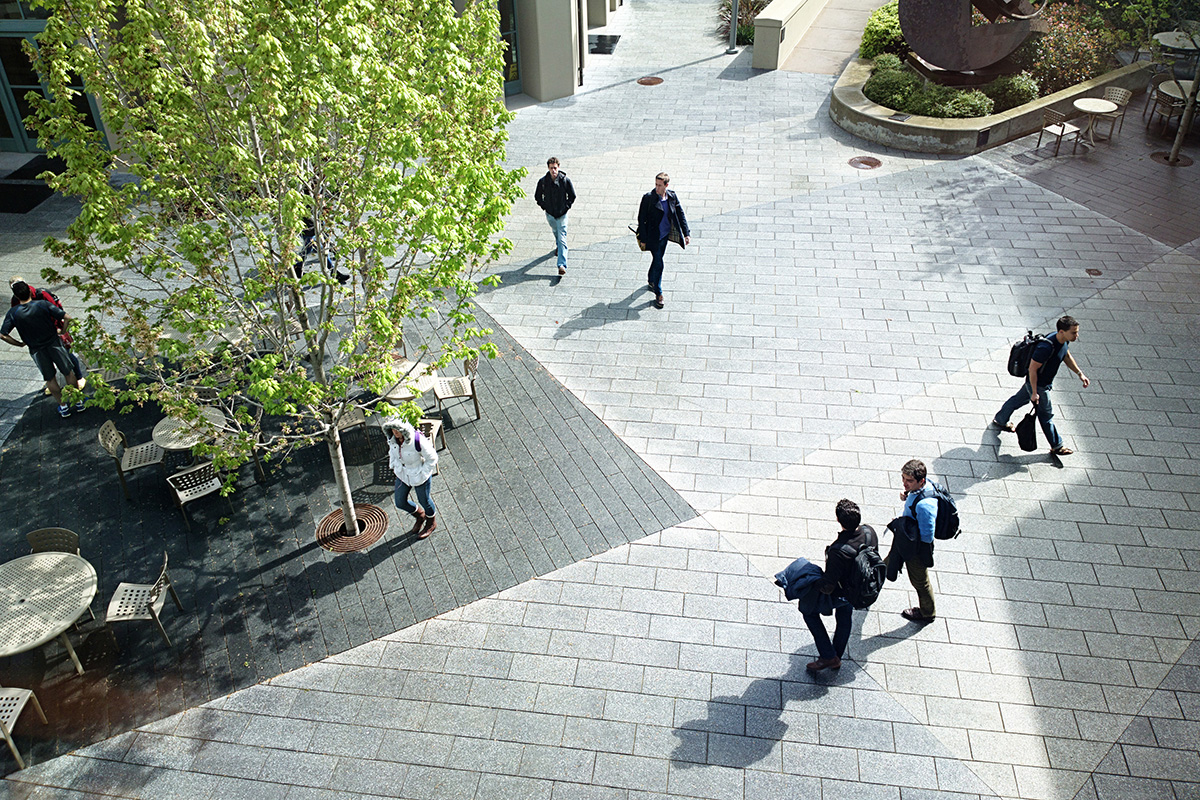Photo of the campus of the University of California, Berkeley. This image is taken from the window of a building of students walking below.