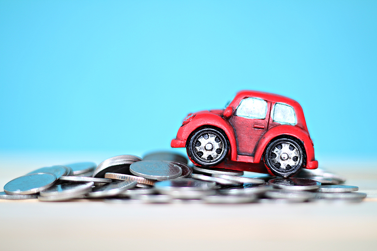 A toy car climbs a hill of money coins