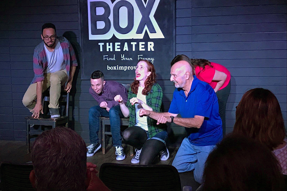 improv class students perform on stage at a theater.