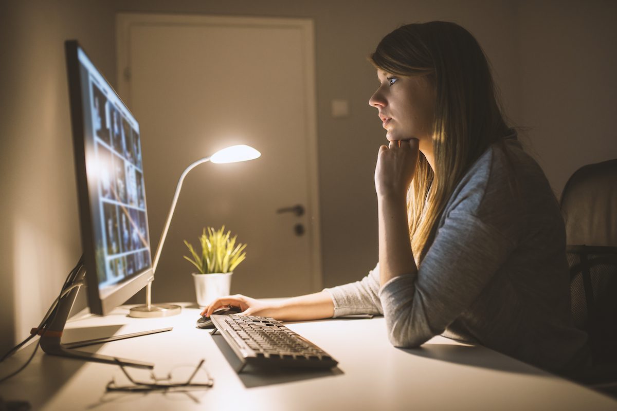 Woman working on computer at night.