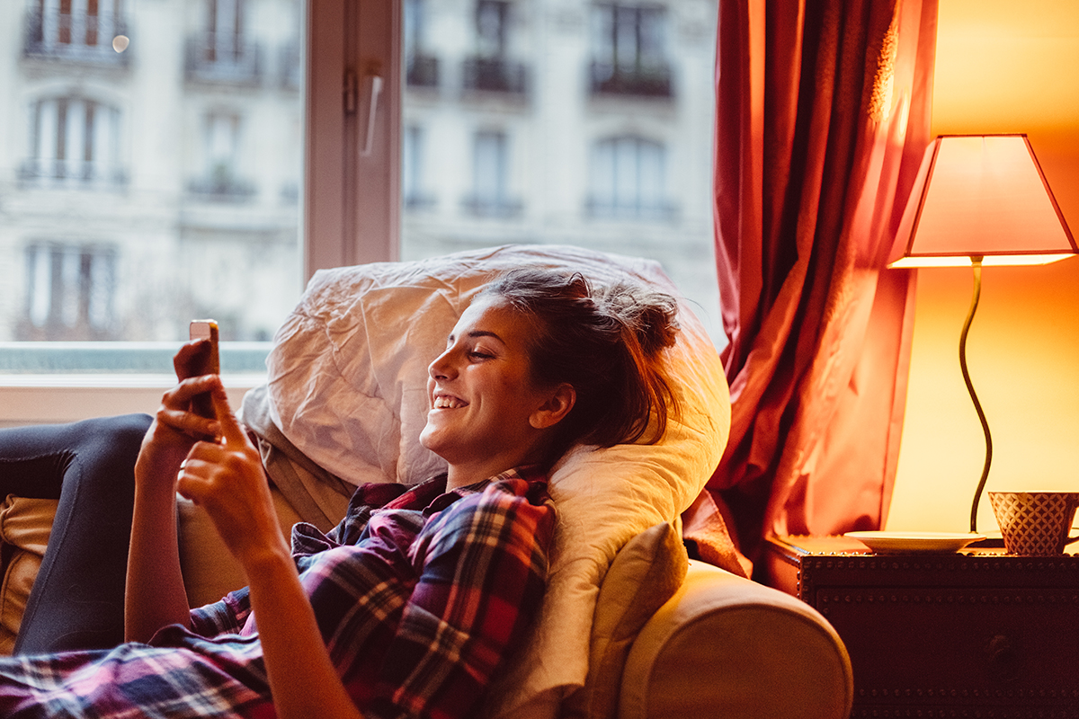 Happy woman at home text messaging
