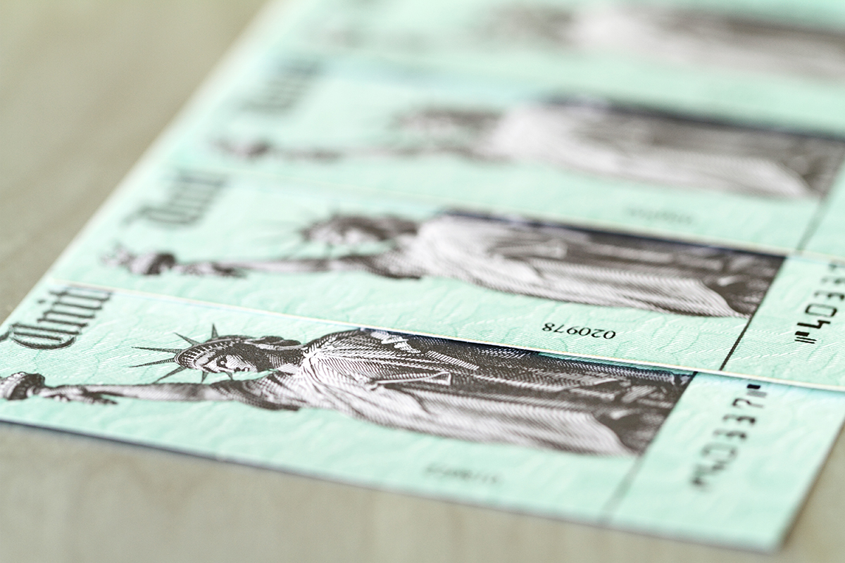 A line of US Treasury checks with selective focus on first check.