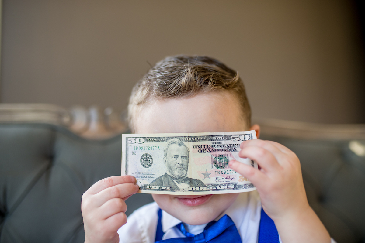 Boy holding fifty dollar bill