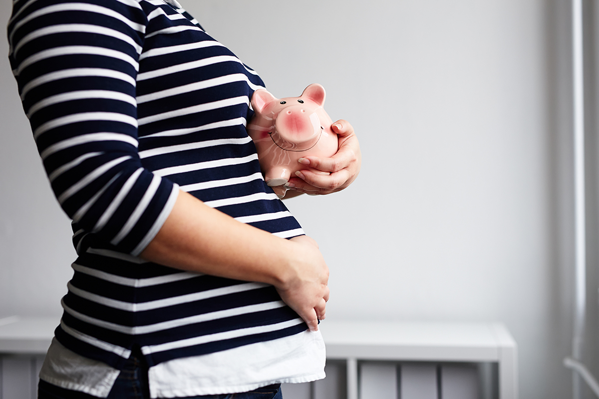 Pregnant woman with piggy bank