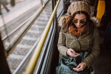 Woman listening music on her smart phone in trolley bus