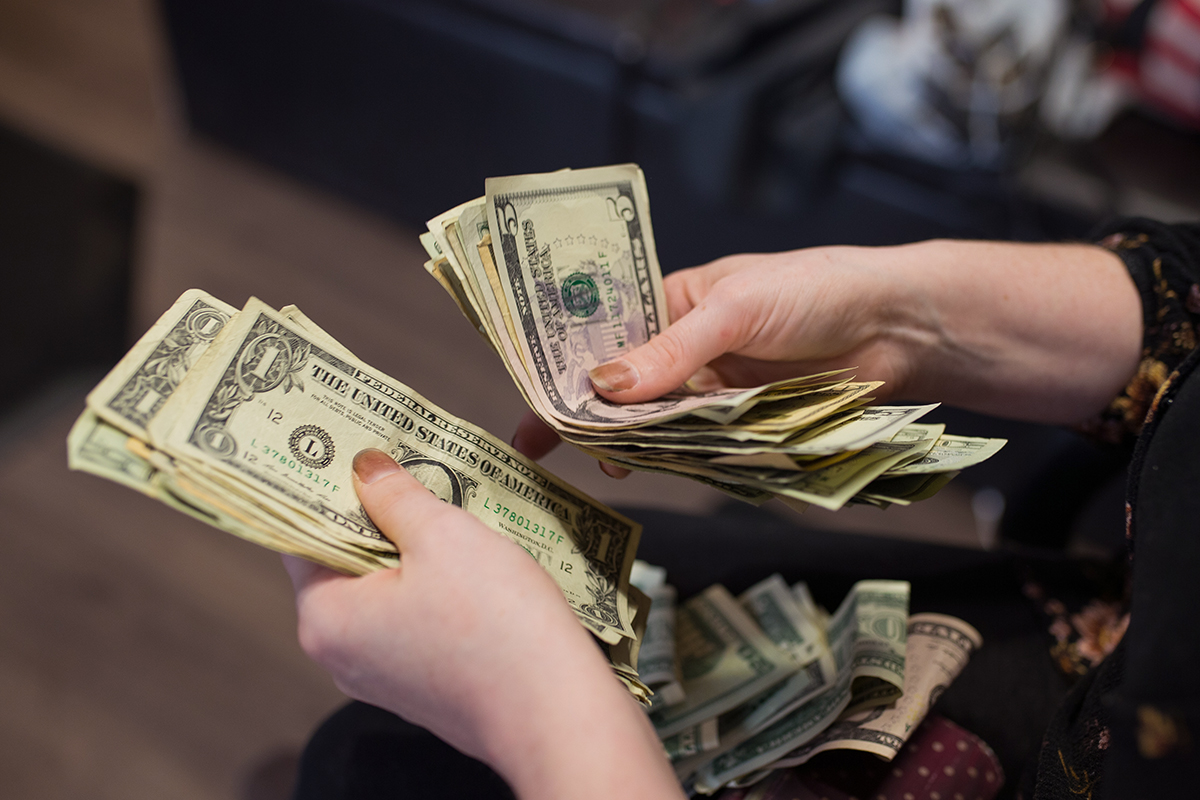 a woman's hands count money.