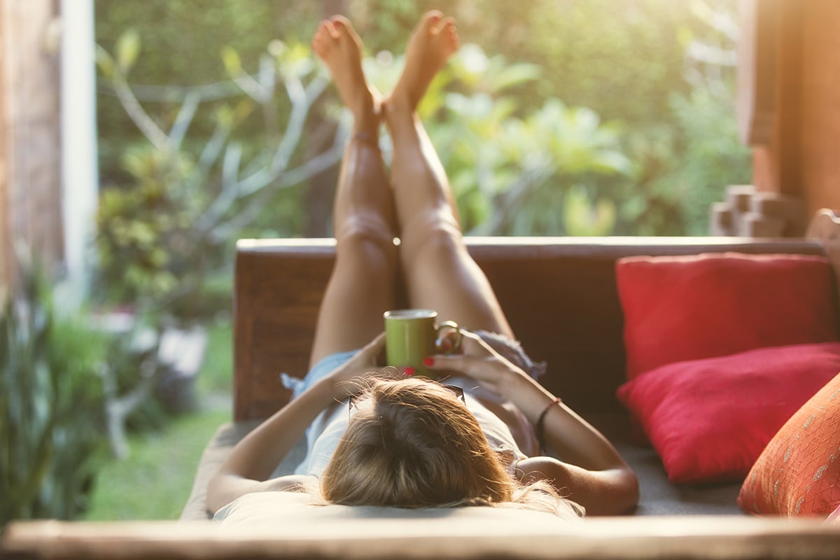 Girl drinking coffee / tea and enjoying the sunrise / sunset in garden.