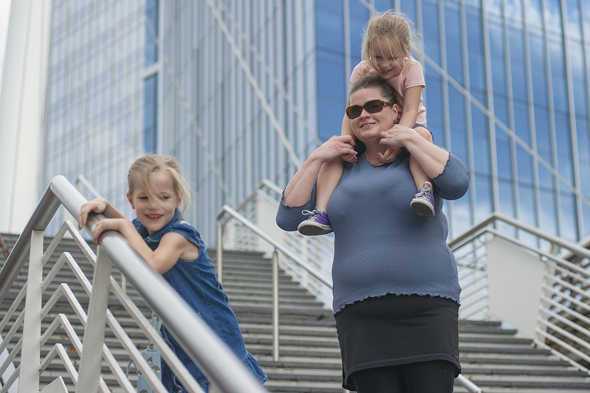 Lakewood, CO resident Linnea Nelson carries her niece Paige Rogers, 4, on her shoulders while Skylar Rogers, 7, uses a railing during their walk on the Millennium Bridge in Denver, Colorado,