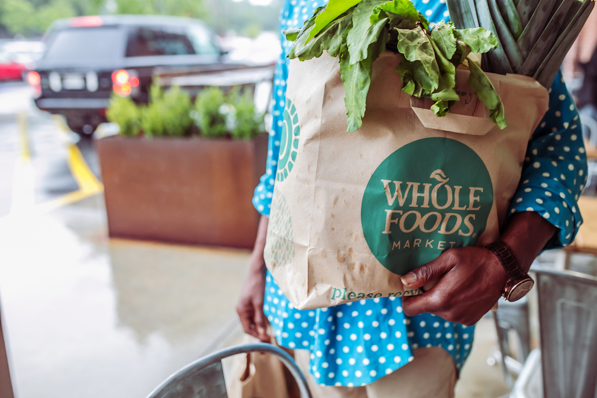 A customer holds a grocery bag outside a Whole Foods in Atlanta, GA.