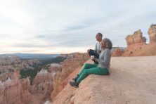 A couple sits on the cliff side to enjoy coffee and the view