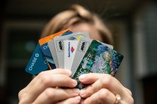 A woman's hands hold a lot of credit cards.