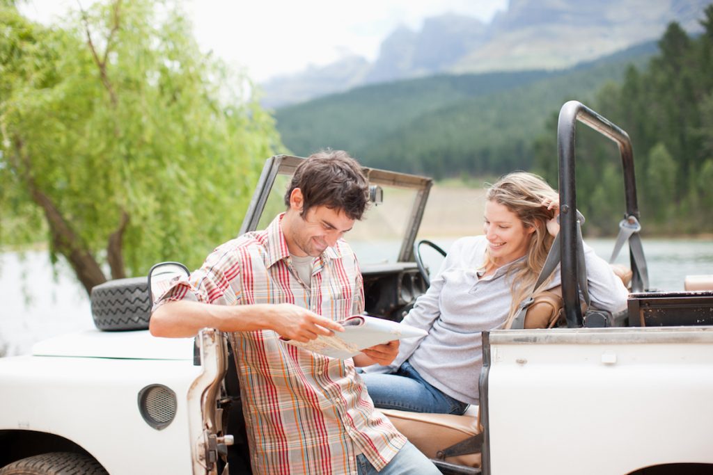 Couple in vehicle looking at map.