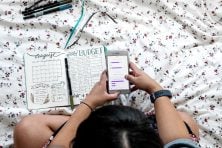 Woman on a bed looking at her phone