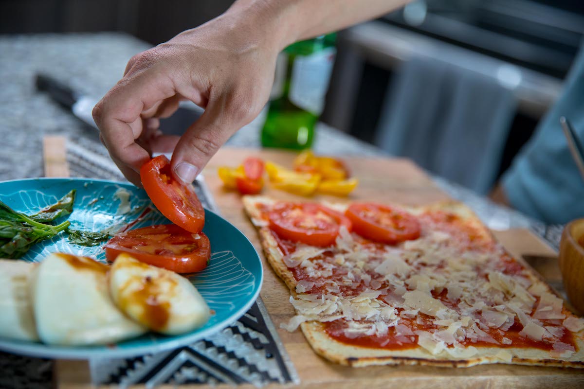 A homemade pizza is shown, along with a plate of mozzarella and tomatoes.