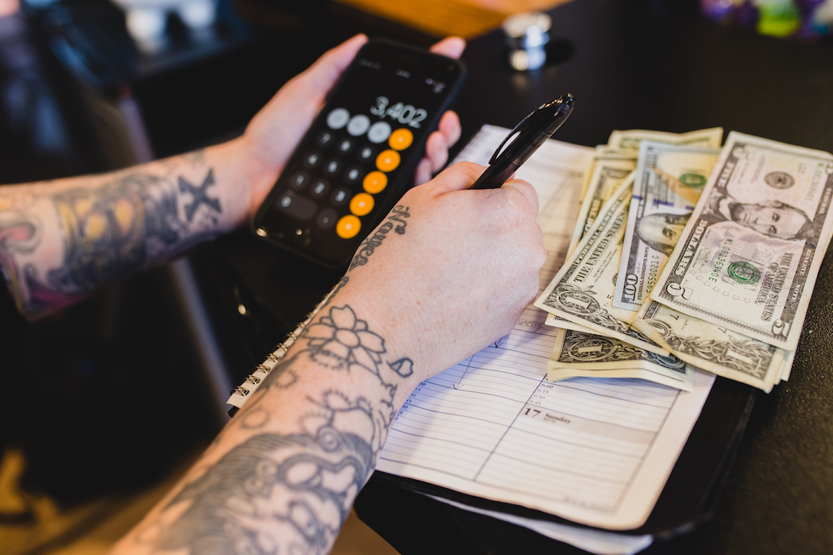 A woman counts money and organizes her bills.