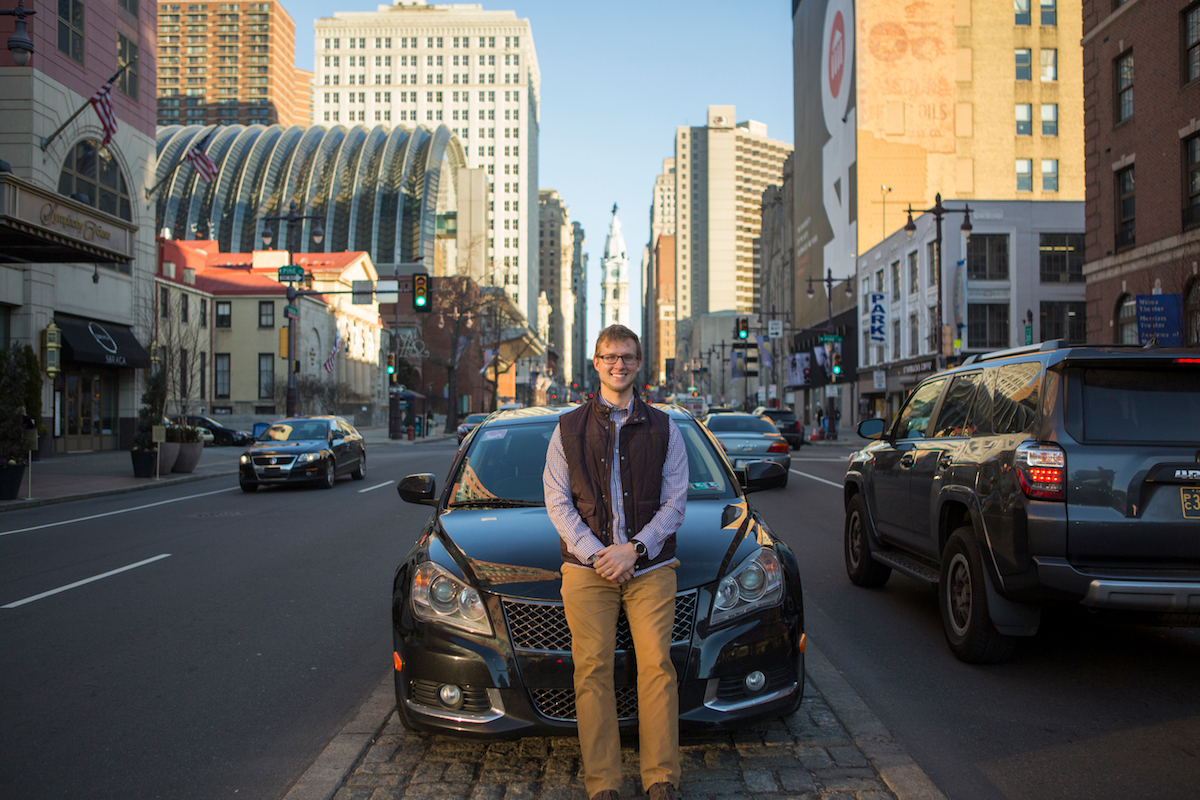 Lyft driver Paul Pruce stands in front of his vehicle in Philadelphia