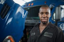 Nicholas Lawrence posing for a portrait at his repair shop