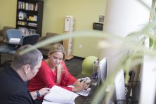 A woman helps a student with her new hire paperwork at USF.
