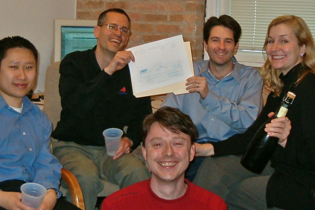 A group of business owners in an office pose for a photo