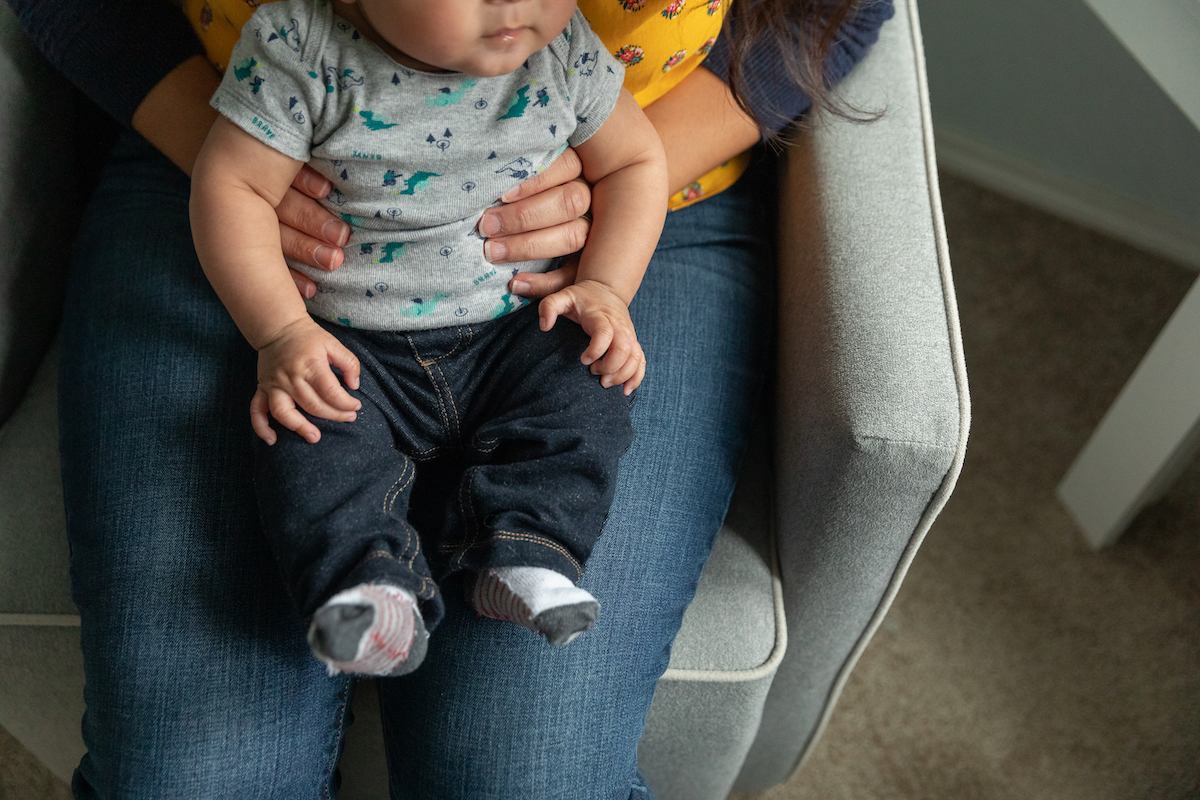 Palmer holds her son in his nursery.