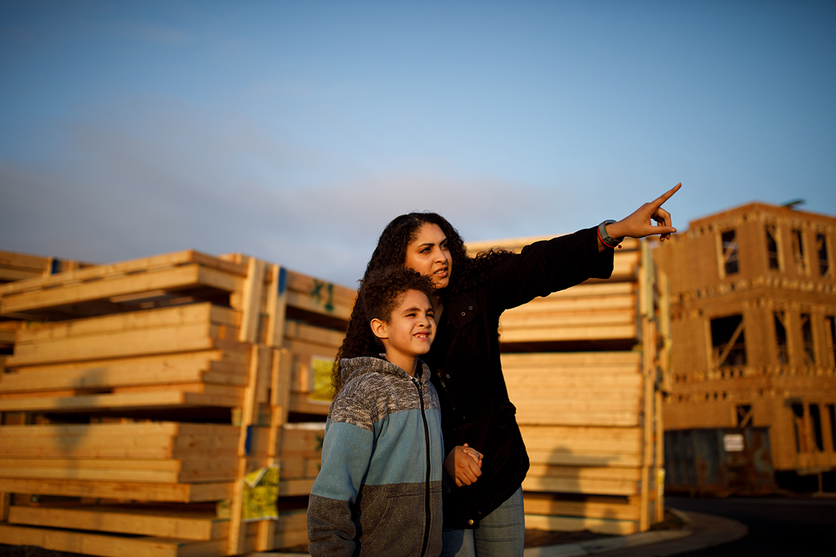 Rebekah Pearsall, and her son, Riley,7, tour the construction site of their new house that is under construction, in Ashburn, VA, on Dec. 2.