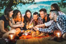 Friends celebrating a birthday and having fun with fire sparkles.