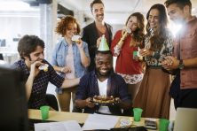 Close up of a group of work colleagues celebrating a birthday.