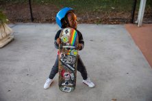 A boy holds a skateboard