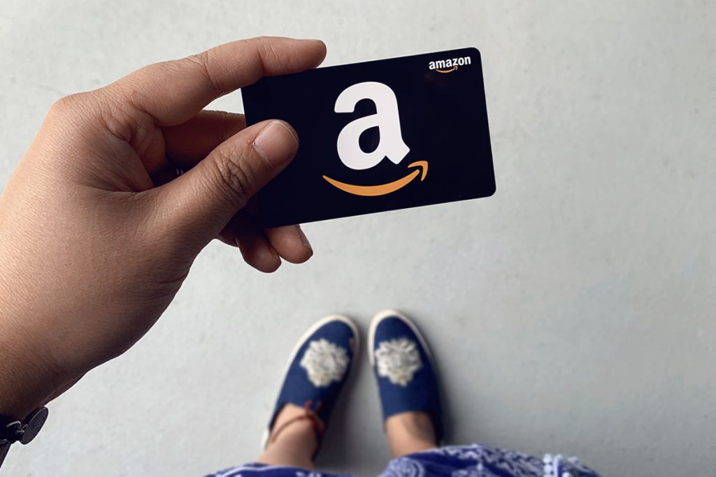 woman holding up amazon gift card