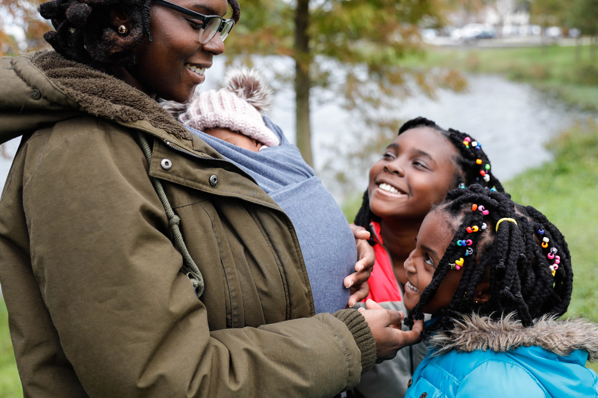 A woman interacts with her daughters outside.