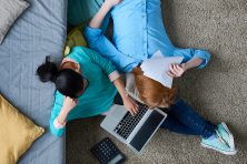 Directly above view of exhausted couple trying to cope with taxes, they doing paperwork together