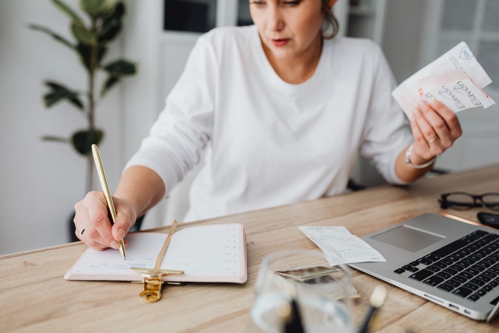 Person organizing their monthly expenses into budget categories