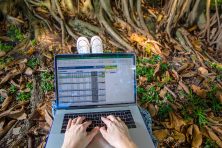 A woman types on a laptop