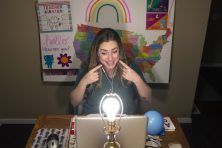 A woman uses a laptop to teach online from her home.
