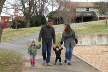 Derick Davis walks with his wide and two sons on a sidewalk.