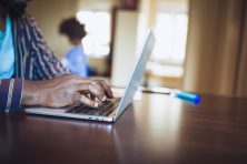 Close - up man working at home, typing on laptop keyboard
