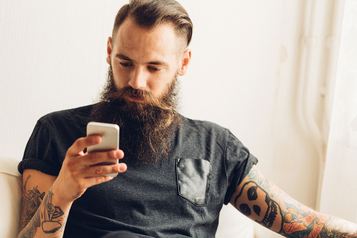 young tattooed man using mobile phone