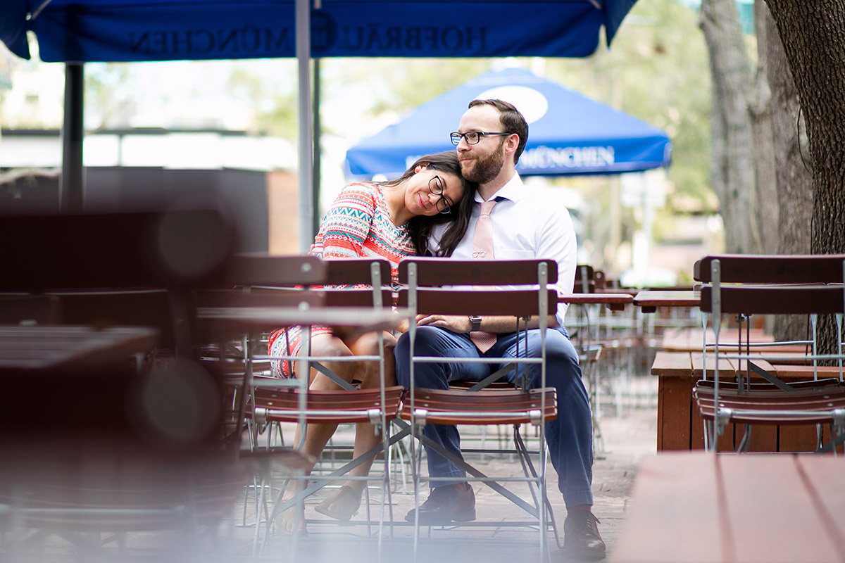 A couple snuggle at a sidewalk cafe.