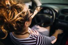 A woman drives a convertible.