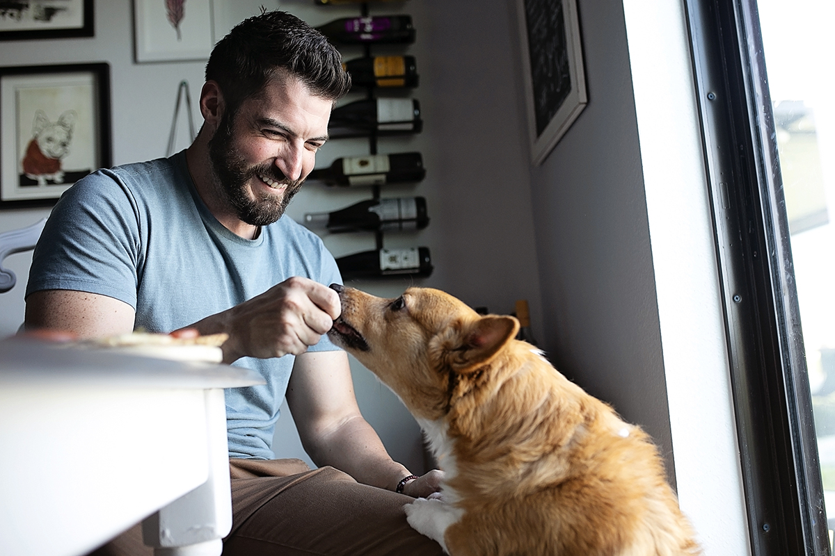 A man feeds a dog a treat.